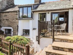 a cottage with a table and chairs on the porch at Cranesbill Barn in Kirkby Stephen