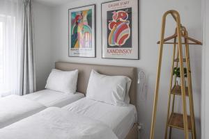 a bedroom with two beds and two framed pictures on the wall at Casselbergh Residences Leader - De Haan in De Haan