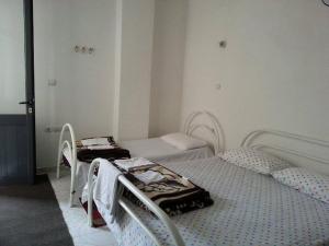 a room with two beds and two chairs in it at Guest House AZA in Pogradec