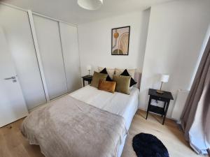 - une chambre avec un lit dans une pièce aux murs blancs dans l'établissement Le Quai des Verts, à Caen