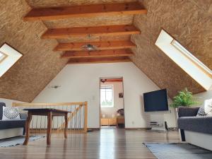 a living room with wooden ceilings and a tv at Dom Porost in Porost