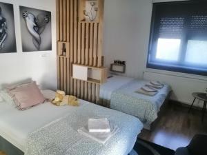 ein Zimmer mit 2 Betten und einem Teddybär darauf. in der Unterkunft Orca Apartman in Jagodina