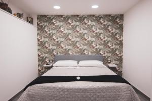 sypialnia z łóżkiem i tapetą w kwiaty w obiekcie Centro Storico Luxury Suites - affittacamere guesthouse in historical center Toledo station w mieście Neapol