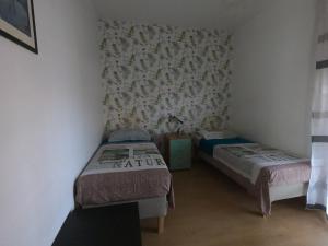 a small room with two beds and a wall at Appartamento Sicilia vicino Caltagirone - Niscemi in Niscemi