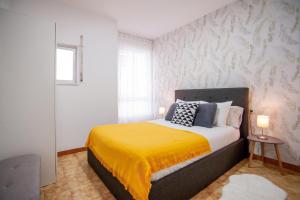 ein Schlafzimmer mit einem Bett mit einer gelben Decke in der Unterkunft Apartamento A pie de Playa in Miño