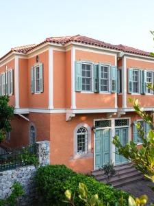 ein Haus mit orangefarbenen und grünen Fensterläden in der Unterkunft 3BR Venetian-style Villa in Mytilene City Centre in Mytilini