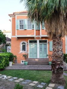 a house with a palm tree in front of it at 3BR Venetian-style Villa in Mytilene City Centre in Mytilini