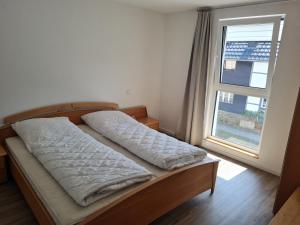 a bed in a room with a large window at Ferienwohnung am Rursee in Simmerath