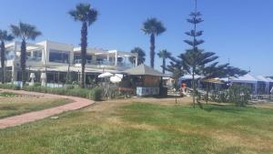 un grand bâtiment avec des palmiers devant lui dans l'établissement Savannah Beach Sidi Rahal, à Casablanca