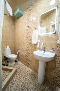 uma casa de banho com um lavatório, um WC e um espelho. em Hamilton em Tashkent