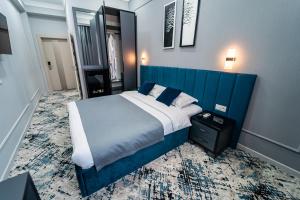 um quarto com uma cama grande e uma cabeceira azul em Hamilton em Tashkent