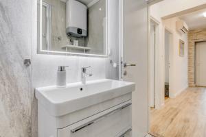 a white bathroom with a sink and a mirror at Da Da in Kaštela +32 photos