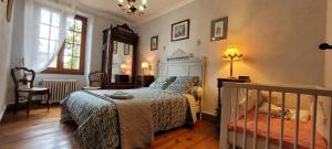 a bedroom with a bed and a crib in it at maison sans vis à vis dans centre historique in Terrasson-Lavilledieu