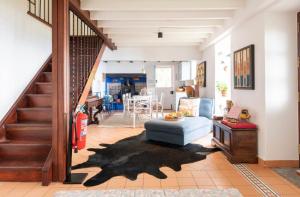 sala de estar con escalera y silla azul en Quinta Belmonte Funchal en Funchal