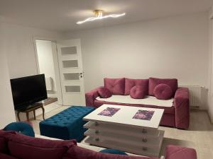 a living room with a red couch and a tv at Apartman SARA in Sarajevo