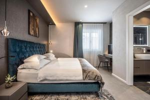 a bedroom with a large bed and a bathroom at Quellenhof Luxury Resort Lazise in Lazise