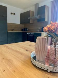 a vase on a table with a vase of flowers at Apart Alpenherz in Schwendau