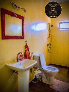 a bathroom with a sink and a toilet and a mirror at MAISON FLORAL in Saly Portudal