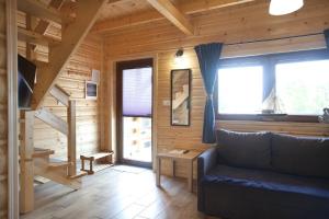 una sala de estar con sofá en una cabaña de madera en LAZUROWY ZAKĄTEK, en Niechorze