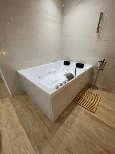 een wit bad in een kamer met een houten vloer bij Luxury - 5 Stars - Suite 70's rooms in Trapani