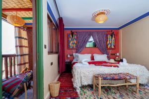 - une chambre avec un lit aux murs rouges dans l'établissement Smile House Imlil, à Imlil