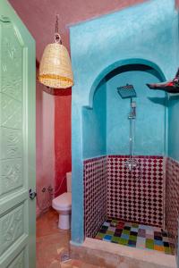 La salle de bains est pourvue d'une douche colorée et de toilettes. dans l'établissement Smile House Imlil, à Imlil