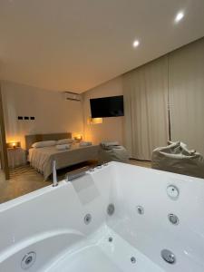 een groot bad in een kamer met een slaapkamer bij Luxury - 5 Stars - Suite 70's rooms in Trapani