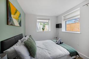 a bedroom with a bed and two windows at Stylish Good Location Near Tamar Bridge in Saltash