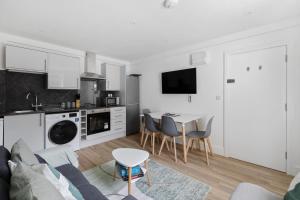 a kitchen and living room with a couch and a table at Stylish Good Location Near Tamar Bridge in Saltash
