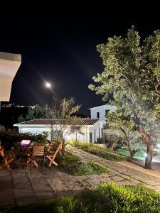 a building with a table and benches at night at Domi Beach Valley in Dhërmi