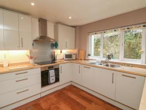 a kitchen with white cabinets and a sink at Lynmouth View in Lynmouth