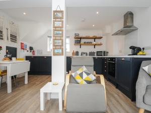 a kitchen and living room with a couch and a table at Wheal Charlotte Cottage in Penzance