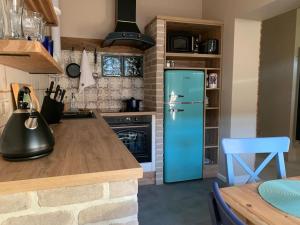 eine Küche mit einem blauen Kühlschrank und einem Tisch in der Unterkunft Oak House in Świebodzin