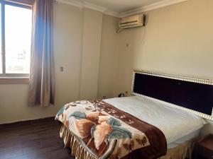 Un dormitorio con una cama en una habitación con ventana. en Shengtang Business Hotel, en Johannesburgo