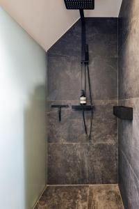 a bathroom with a stone shower with a light fixture at Moxn Chalet Lungau - Authentic Luxury Living in Ramingstein