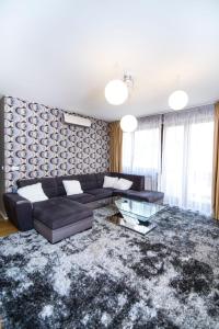 ブダペストにあるPaulay free parking luxury design apartman with terazzeの黒いソファとガラスのテーブルのあるリビングルーム