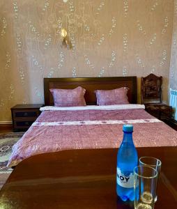 a bed with a bottle and two glasses on a table at Christy Hotel in Goris