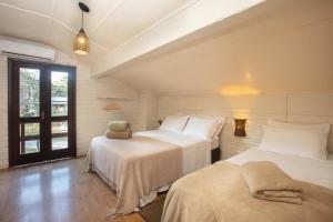 a bedroom with two beds and a window at Casa no Campo Caminho do Salto in Farroupilha