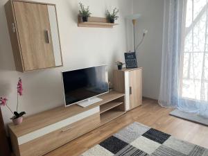 a living room with a flat screen tv on a cabinet at Ferienwohnung Andreea in Vlotho