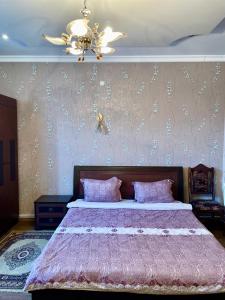 a bedroom with a large bed with a chandelier at Christy Hotel in Goris