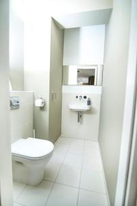 a white bathroom with a toilet and a sink at Paulay free parking design 51 apartman with terazze in Budapest