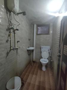 a small bathroom with a toilet and a sink at Hotel Shubhadra Guest House in Mathura