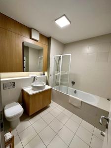 a bathroom with a toilet and a sink and a tub at Paulay free parking design 51 apartman with terazze in Budapest