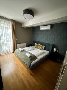 a bedroom with a bed with a green wall at Paulay free parking design 51 apartman with terazze in Budapest