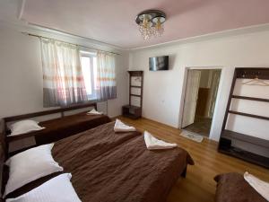 een slaapkamer met 2 bedden en een kroonluchter bij Family ЛюКс in Kamjanets-Podilsky