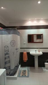 a bathroom with a shower curtain and a sink at Habitación privada con baño compartido 