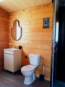 uma casa de banho com um WC e um lavatório numa parede de madeira em Casa da Ria em Gafanha da Boa Hora