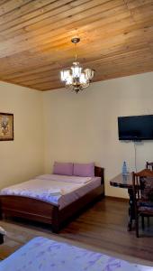 1 dormitorio con cama, mesa y lámpara de araña en Christy Hotel, en Goris