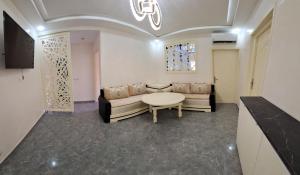 a living room with a couch and a table at Appartement moderne haut standing avec balcon et clim à 2 min de la plage in Saïdia