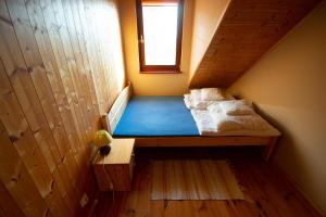 a small room with a bed in the attic at Apartamenty Rodzinne Łukęcin in Łukęcin